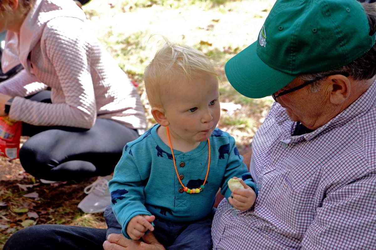 baby sitting on lap of older man at sprindale mill celebration