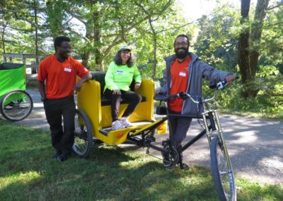 WooRides pedicab bike with two drivers and a passenger ready to go