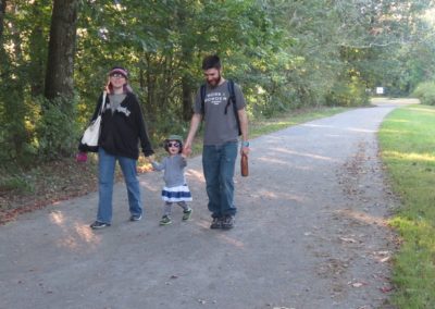 Couple walking with small child on rail trail